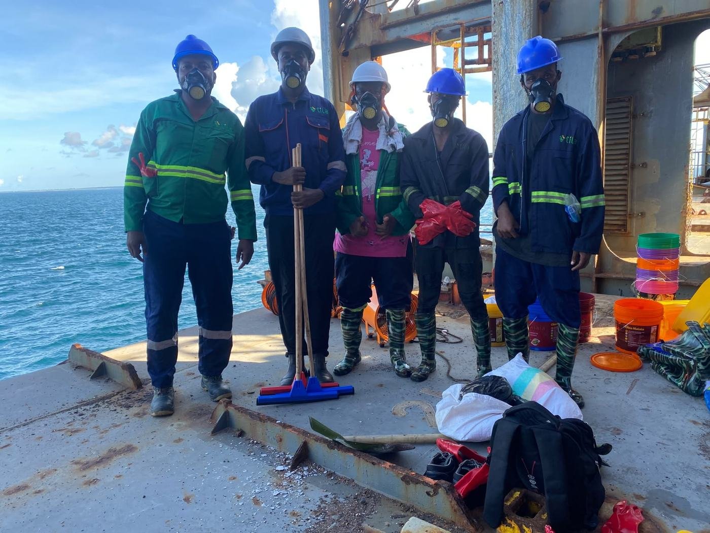 Equipa da Tila no convés de um navio, com equipamento de protecção