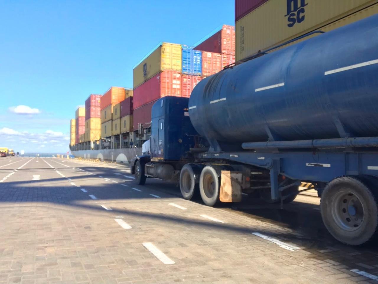Tanker truck next to containers
